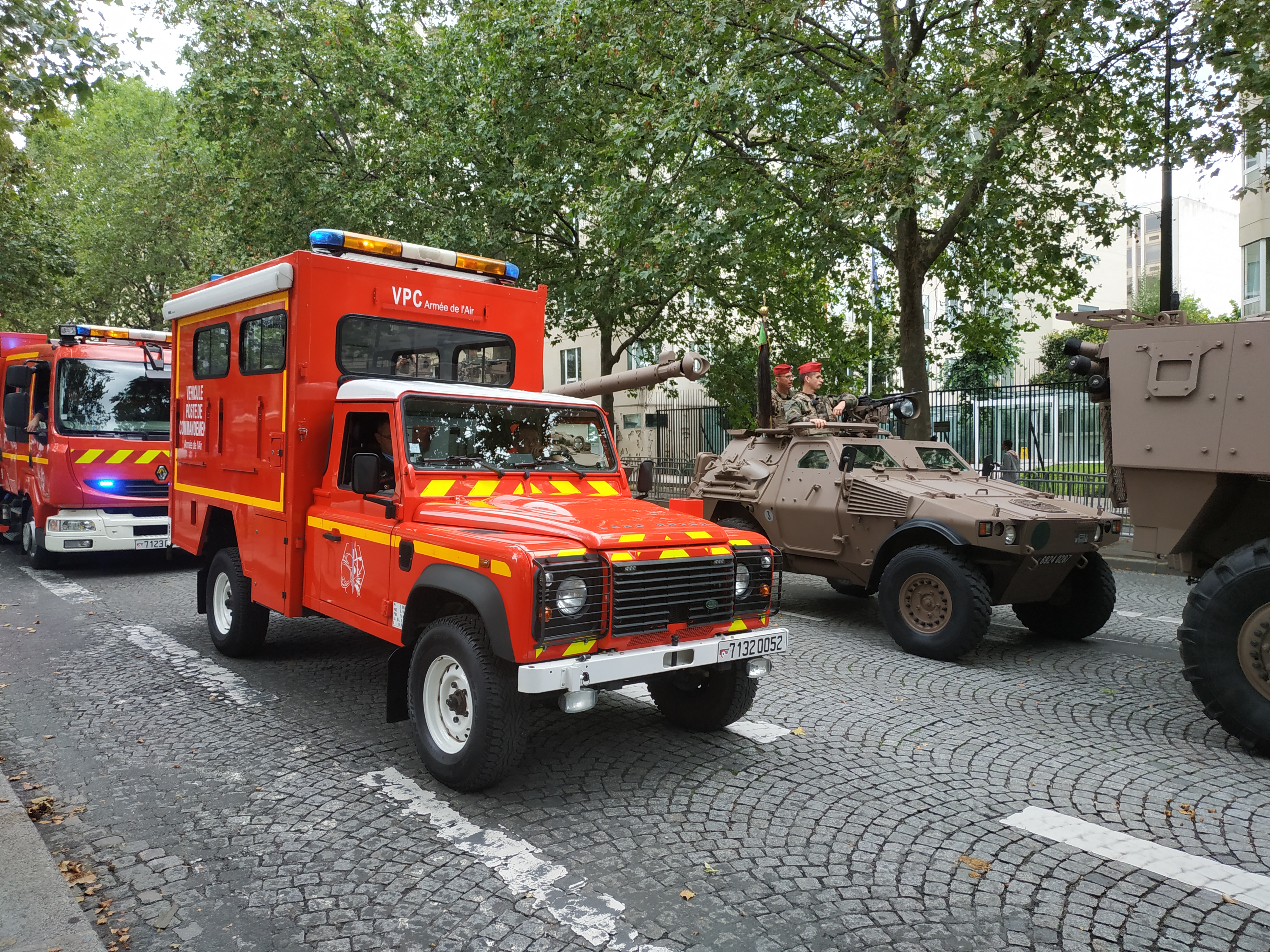 Armée de l'Air VPC 7132 0052 on the Bastille Day parade, Paris, 14 July 2021 — box body lettered VÉHICULE POSTE DE COMMANDEMENT, roller-shutter lockers, blue lightbar and convex Puma bonnet