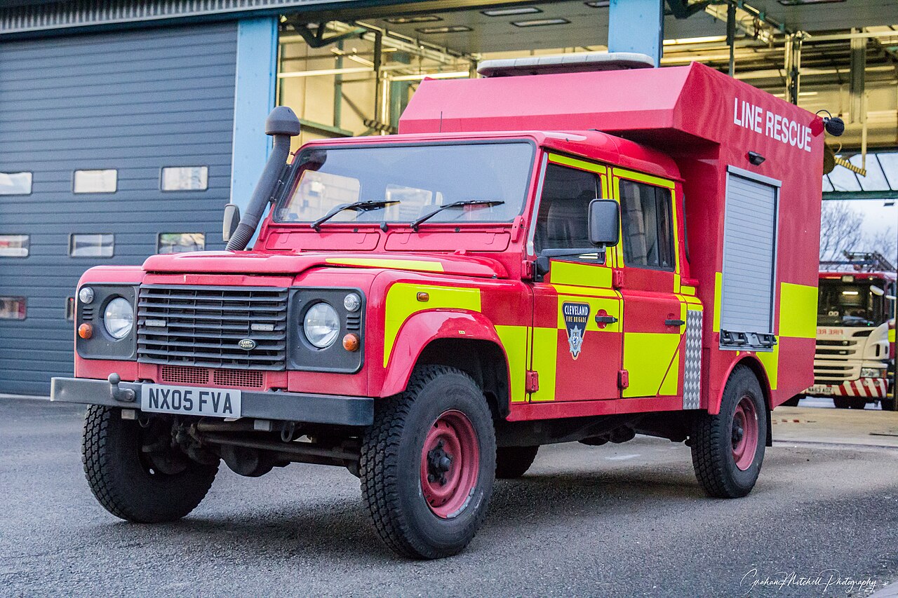 The same Line Rescue Defender on the station forecourt, showing the roller-shutter box body and yellow high-visibility panelling