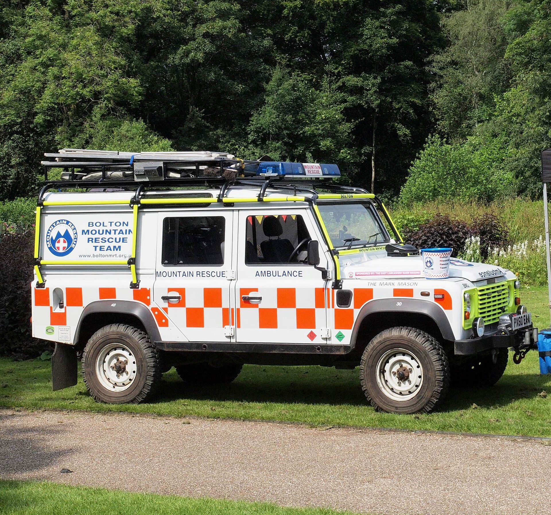 Bolton Mountain Rescue Team Defender 110 rescue ambulance in the standard MREW white-and-orange livery - the same convention worn by the Dartmoor teams' vehicles